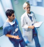 Female Physician walking next to s male Nurse in Hospital